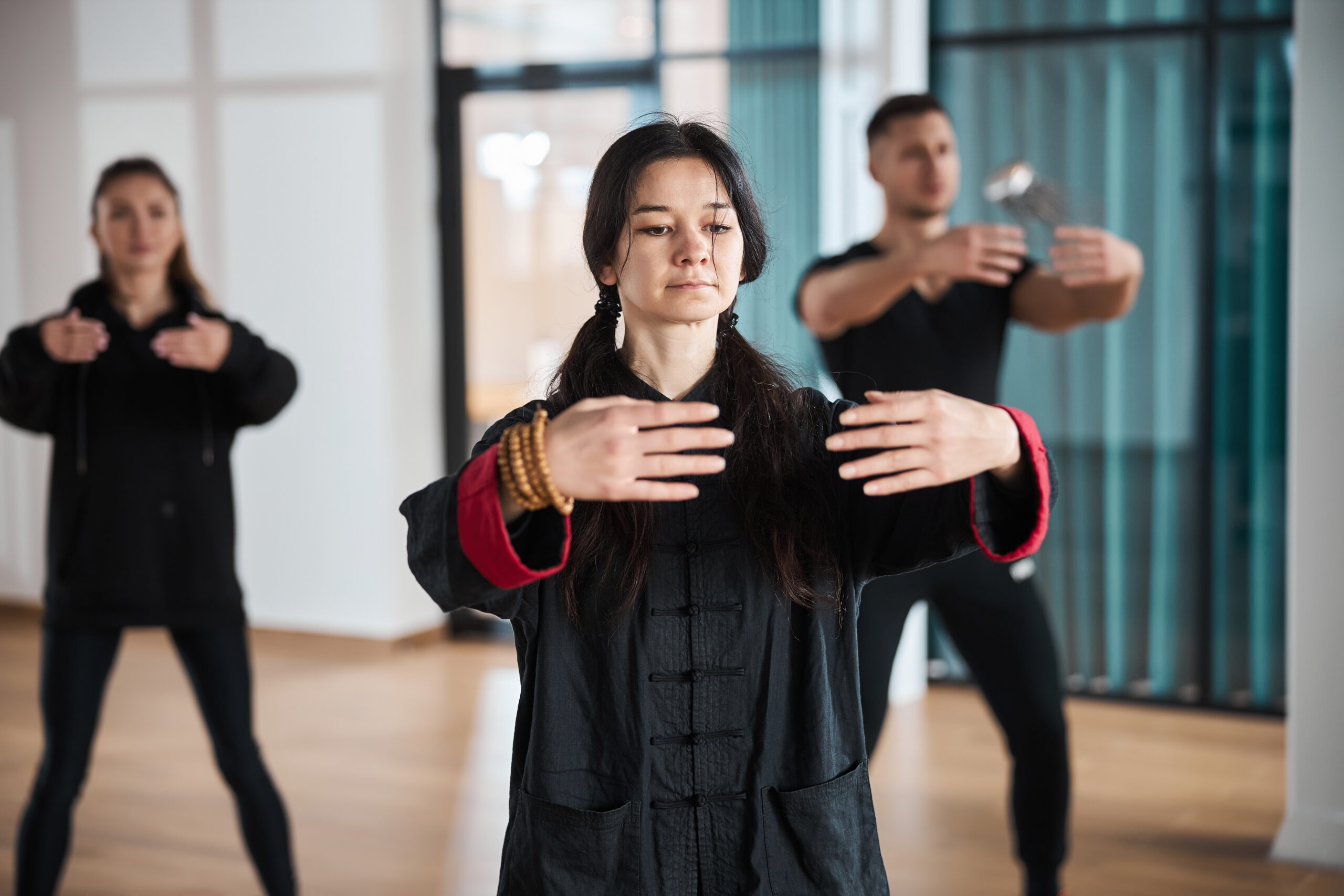 Composed qigong coach doing embrace gesture with arms